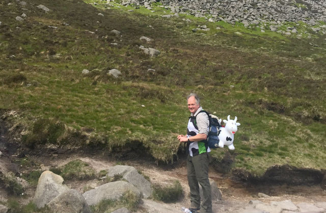 Robert Huey Chief Veterinary Officer Northern Island, pictured with inflatable cow about to start hiking up the mountain.