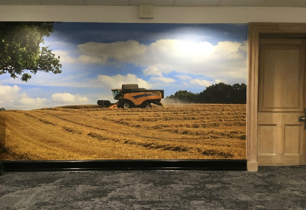 An image of a combine harvester mural on a wall with a door on the left