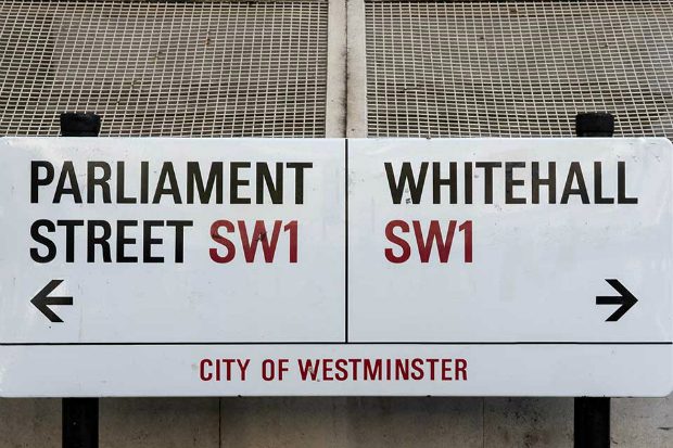 A street sign indicating parliament street to the left and Whitehall to the right.