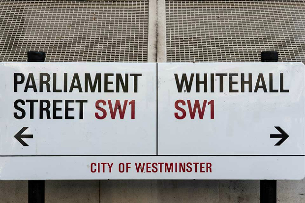 A street sign indicating parliament street to the left and Whitehall to the right. 