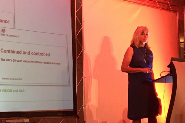 Christine standing in front of a presentation behind a lectern.