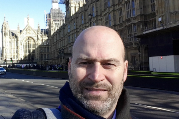 Enrique standing in front of the houses of parliament