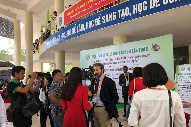 Javier talking with a group of people in a conference centre