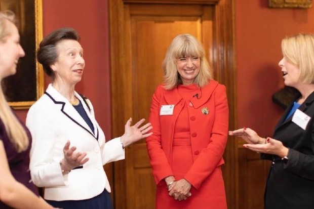 Christine standing in a room with three other people