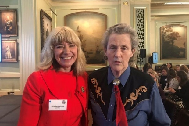 Christine standing in a room with Temple Grandin