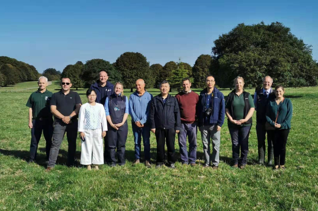 Carmen standing in a field with a group of officials