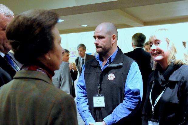 Kate standing in a large room surrounded by four people