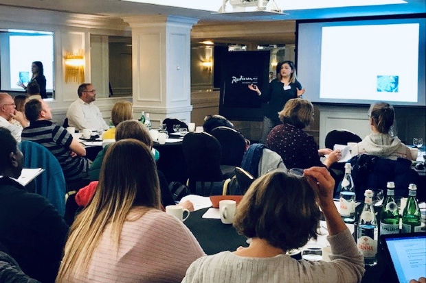 Carmen presenting in front of a group at a training event